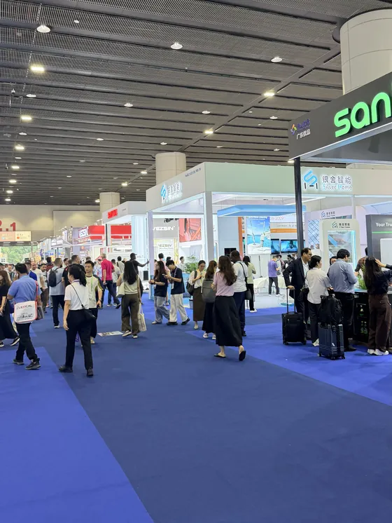 Aisle of exhibitor booths and buyers inside a Canton Fair hall