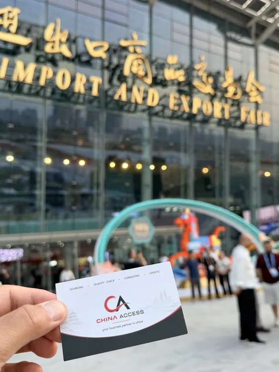 China Access business card in front of the Canton Fair entrance in Guangzhou