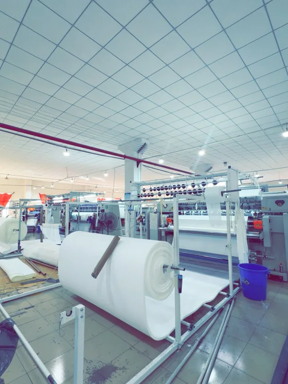 Textile production machine with a roll of material running